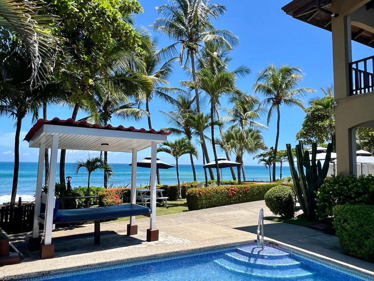 Pool, palm trees and the Pacific Ocean at Backyard Hotel, Playa Hermosa