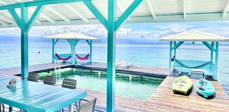 Pool deck at Casa Clearwater with hammock gazebos over the reef in Bocas del Toro